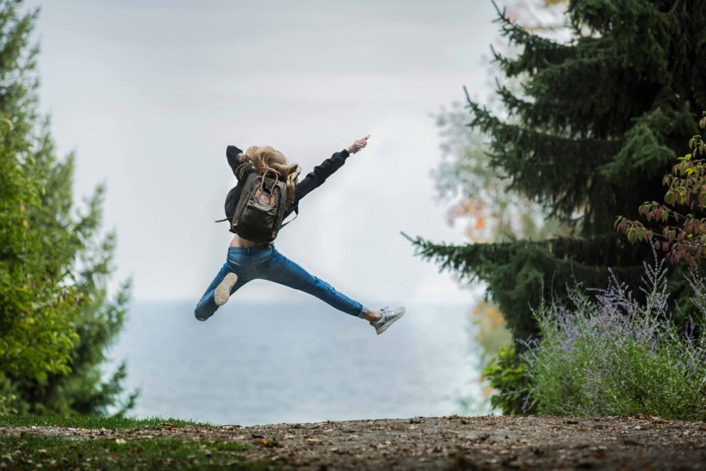 7 Self Care Party Ideas You Will Love for Better Well-Being 4 Woman-Jumping-Wearing-Green-Backpack