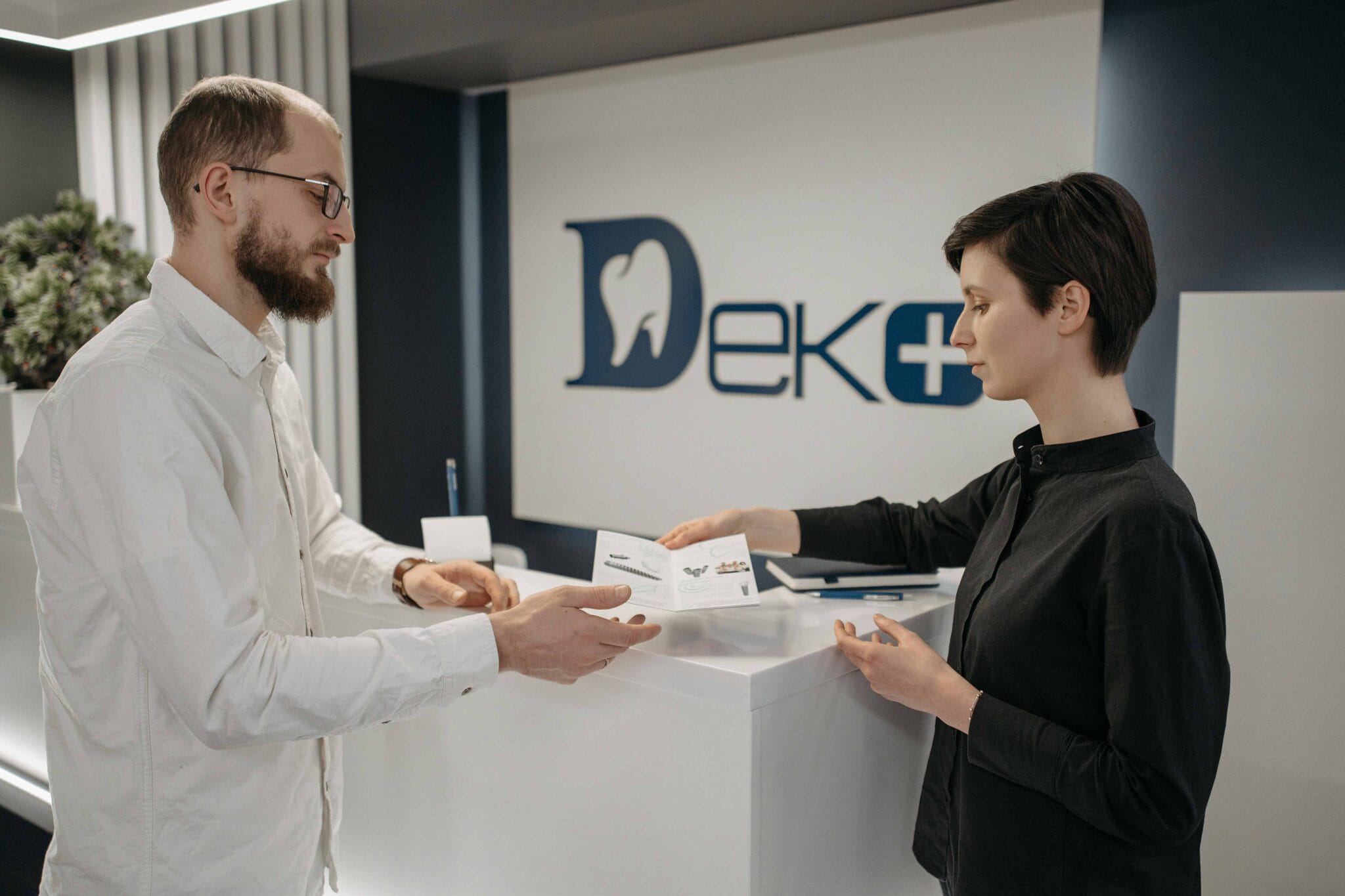 Do Holistic Dentists Take Insurance 2 photo-of-a-man-and-woman-at-dental-clinic-woman-taking-insurance-papers-