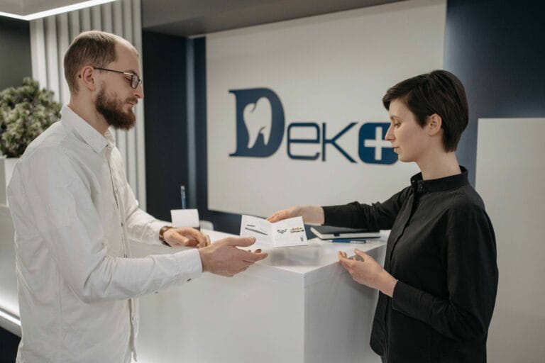 Do Holistic Dentists Take Insurance 1 photo-of-a-man-and-woman-at-dental-clinic-woman-taking-insurance-papers-